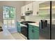 Stylish kitchen features a stainless steel refrigerator, oven, and sleek green cabinets with modern white backsplash at 6213 Marbut Farms Chase, Lithonia, GA 30058