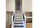 View up staircase shows natural wood flooring, white risers, and black railings at 6213 Marbut Farms Chase, Lithonia, GA 30058
