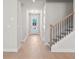 Bright entryway with hardwood floors, staircase, and a white front door leading to the outside at 920 Melody Ridge Ln, Buford, GA 30518