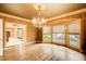 Formal dining room featuring an elegant chandelier, hardwood floors, and bay windows overlooking the garden at 305 Heards Ferry Rd, Atlanta, GA 30328