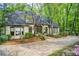 Elegant home with a symmetrical facade, bay windows, and a paved driveway lined with trees and landscaping at 305 Heards Ferry Rd, Atlanta, GA 30328
