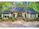 Charming home featuring a symmetrically designed exterior with a gray roof and beautiful front yard landscaping at 305 Heards Ferry Rd, Atlanta, GA 30328