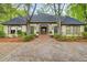 Stately home with a grand entrance, bay windows, and mature trees framing the property at 305 Heards Ferry Rd, Atlanta, GA 30328