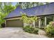 Home featuring a two-car garage, enhanced landscaping, and a walkway leading to the front entrance at 305 Heards Ferry Rd, Atlanta, GA 30328