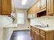 Practical laundry room with wooden cabinets, a sink, and a folding table at 305 Heards Ferry Rd, Atlanta, GA 30328