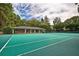 A well-maintained tennis court with surrounding trees and a nearby club house at 3665 Essex Ave # 28, Atlanta, GA 30339