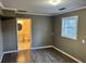 Spacious bedroom with gray vinyl plank flooring, neutral walls, large window, and adjoining bathroom at 4844 Fairforest Dr, Stone Mountain, GA 30088