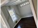 Bright bedroom featuring wood floors, a large window, and modern light fixture at 4844 Fairforest Dr, Stone Mountain, GA 30088