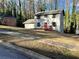 Charming two-story home with a red front porch and well-maintained lawn surrounded by mature trees at 4844 Fairforest Dr, Stone Mountain, GA 30088