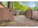 Gravel parking area in backyard with access through wooden fence and surrounded by lush trees at 758 Argonne Ne Ave, Atlanta, GA 30308