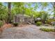 Backyard with a wooden patio, and a gravel parking area surrounded by lush trees at 758 Argonne Ne Ave, Atlanta, GA 30308