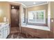 Bright bathroom showcasing a walk-in shower, a bathtub with stone tile surround, and natural light at 4431 Skyland Ne Dr, Atlanta, GA 30342