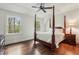Cozy bedroom with dark hardwood floors, a four-poster bed, and two sun-filled windows at 4431 Skyland Ne Dr, Atlanta, GA 30342