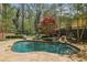 Backyard pool with stone patio, mature trees, and lounge seating at 4431 Skyland Ne Dr, Atlanta, GA 30342