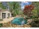 Backyard pool with stone patio, mature trees, and lounge seating at 4431 Skyland Ne Dr, Atlanta, GA 30342