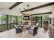 Screened porch featuring a stone fireplace, wood beams, and multiple seating areas with comfortable furniture at 4431 Skyland Ne Dr, Atlanta, GA 30342