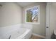 Bathroom features large soaking tub with window views of wooded landscape at 4866 Pinnacle Dr, Stone Mountain, GA 30088