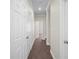 Well lit hallway features neutral walls and flooring, with white doors and trim throughout at 4866 Pinnacle Dr, Stone Mountain, GA 30088
