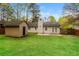 This backyard has a storage shed, a grass lawn, and a privacy fence at 8404 Park Ridge Ln, Riverdale, GA 30274