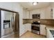 Modern kitchen with stainless steel appliances, white cabinets, and tile backsplash at 8404 Park Ridge Ln, Riverdale, GA 30274