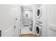 Hallway featuring a stacked washer/dryer and an open door to a beautifully tiled bathroom at 860 Peachtree Ne St # 1103, Atlanta, GA 30308