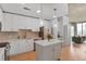Bright kitchen features white cabinets, stainless appliances, an island, and views of the living area at 860 Peachtree Ne St # 1103, Atlanta, GA 30308