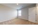 Bedroom featuring carpeted floors, a window for natural light, and a door leading to another area at 164 Weldon Rd, Mcdonough, GA 30253