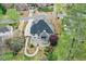 An aerial view shows the home with a basketball court area and a screened porch surrounded by trees at 204 Maple Creek Chase, Woodstock, GA 30188