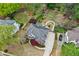 Aerial view of the property featuring lush landscaping, a long driveway, and a brick facade at 204 Maple Creek Chase, Woodstock, GA 30188