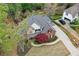 Aerial view of a charming two-story home with lush landscaping, mature trees, and a private driveway at 204 Maple Creek Chase, Woodstock, GA 30188