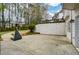 Backyard featuring a basketball court, green trees, and a retaining wall at 204 Maple Creek Chase, Woodstock, GA 30188