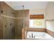 Tiled main bathroom featuring a shower and soaking tub by the window at 204 Maple Creek Chase, Woodstock, GA 30188