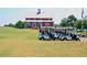 Exterior shot of red clubhouse on a sunny day with a row of parked golf carts at 204 Maple Creek Chase, Woodstock, GA 30188