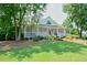 Charming home featuring a classic front porch, mature trees, and a meticulously manicured front lawn at 204 Maple Creek Chase, Woodstock, GA 30188
