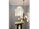 Well-lit foyer featuring a decorative chandelier, arched window, and elegant trim work above the front door at 204 Maple Creek Chase, Woodstock, GA 30188
