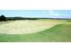 Expansive view of golf course with green grass and flags indicating hole locations on a sunny day at 204 Maple Creek Chase, Woodstock, GA 30188