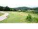 Scenic view of golf course with pond, sand trap, and mature trees on a sunny day at 204 Maple Creek Chase, Woodstock, GA 30188