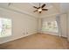 Bright main bedroom featuring a tray ceiling, ceiling fan, and plenty of natural light at 204 Maple Creek Chase, Woodstock, GA 30188