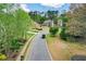 A residential street shows homes with well-manicured lawns and mature trees lining the road at 204 Maple Creek Chase, Woodstock, GA 30188