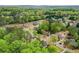 The aerial view captures a home surrounded by mature trees and greenery in a serene setting at 204 Maple Creek Chase, Woodstock, GA 30188