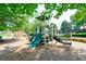 Playground with slides, climbing structures, mature trees and playground on a gravel surface at 204 Maple Creek Chase, Woodstock, GA 30188