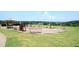 A putting green with seating area and a view of mature trees and rolling hills at 204 Maple Creek Chase, Woodstock, GA 30188