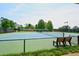 Outdoor tennis court with green and blue surface surrounded by black chain link fence and trees at 204 Maple Creek Chase, Woodstock, GA 30188