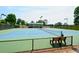 Outdoor tennis court with green and blue surface surrounded by black chain link fence and trees at 204 Maple Creek Chase, Woodstock, GA 30188