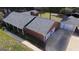 Aerial view of a red brick single story home with a detached two-car garage and extra storage at 2533 Whispering Pines Dr, Grayson, GA 30017