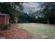 Picture of the backyard featuring a large grassy lawn and a border of pine straw and trees at 2533 Whispering Pines Dr, Grayson, GA 30017