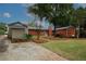 Backyard view featuring mature trees, gravel parking area, garage and the back of the house at 2533 Whispering Pines Dr, Grayson, GA 30017