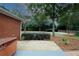 Tranquil backyard featuring a hot tub, patio, gravel, landscaping, and established trees at 2533 Whispering Pines Dr, Grayson, GA 30017