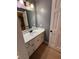 Bright bathroom vanity with white cabinets and a round mirror above sink at 2533 Whispering Pines Dr, Grayson, GA 30017