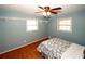 Cozy bedroom with hardwood floors, blue walls, and a classic ceiling fan at 2533 Whispering Pines Dr, Grayson, GA 30017